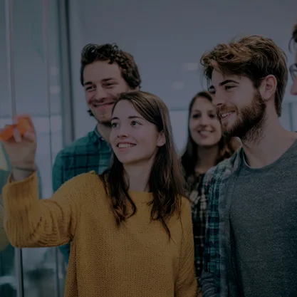 Groupe de personnes qui travaillent ensemble devant un tableau 