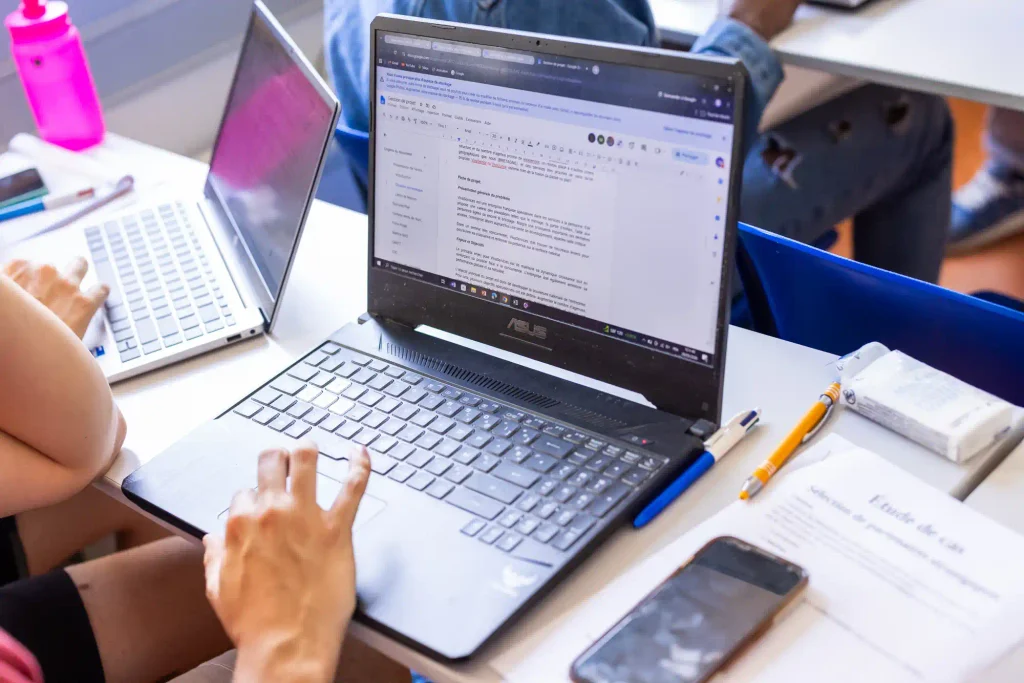 Étudiant sur son ordinateur devant un document Word